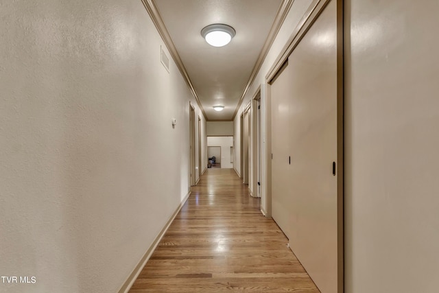 hall featuring light hardwood / wood-style floors and ornamental molding