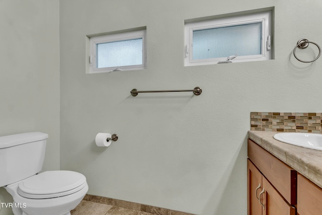 bathroom featuring decorative backsplash, vanity, and toilet