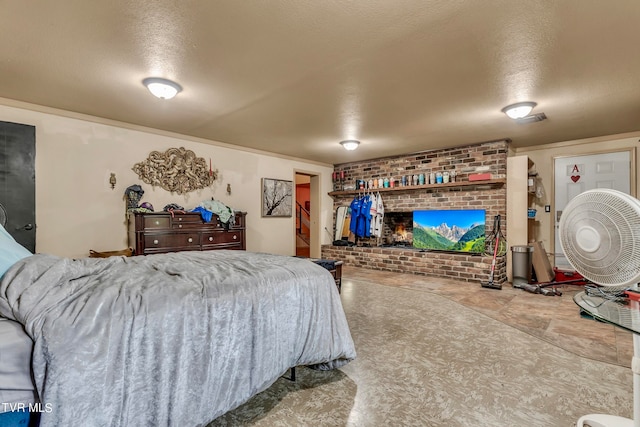 bedroom featuring a textured ceiling and a brick fireplace