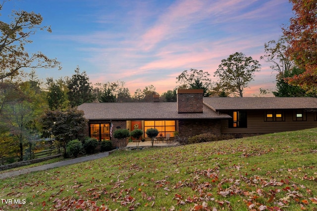 ranch-style house with a lawn and a patio area