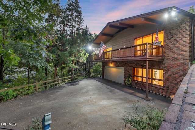 property exterior at dusk with a balcony and a garage