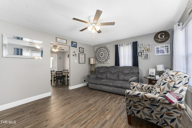 living room with plenty of natural light, dark wood-type flooring, and a textured ceiling