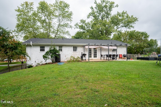 rear view of property with a lawn, a patio area, and french doors