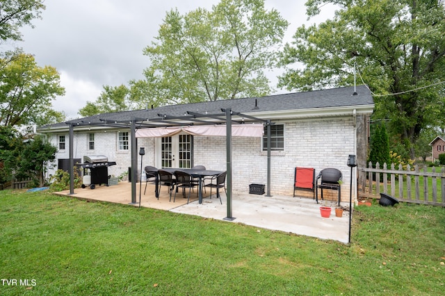 back of property with a yard and a patio area