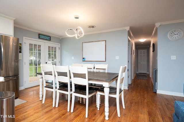 dining area featuring crown molding, french doors, and hardwood / wood-style flooring