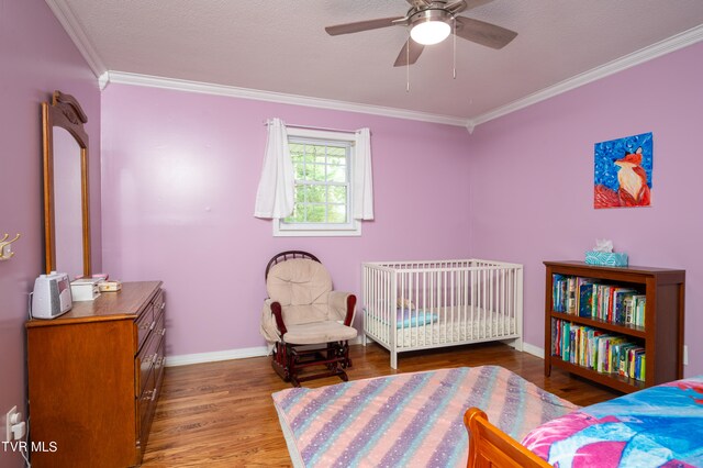 bedroom with a textured ceiling, wood-type flooring, crown molding, and ceiling fan