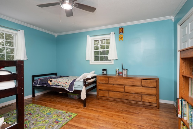 bedroom with multiple windows, crown molding, ceiling fan, and light hardwood / wood-style flooring