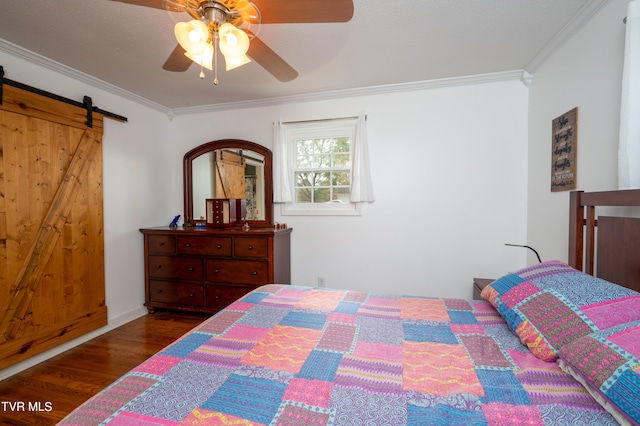 bedroom featuring a barn door, ornamental molding, dark hardwood / wood-style flooring, and ceiling fan