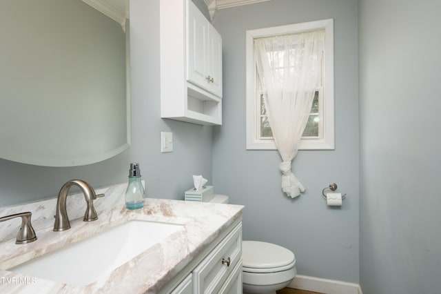 bathroom with crown molding, vanity, and toilet