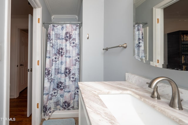 bathroom featuring wood-type flooring, vanity, walk in shower, and ornamental molding