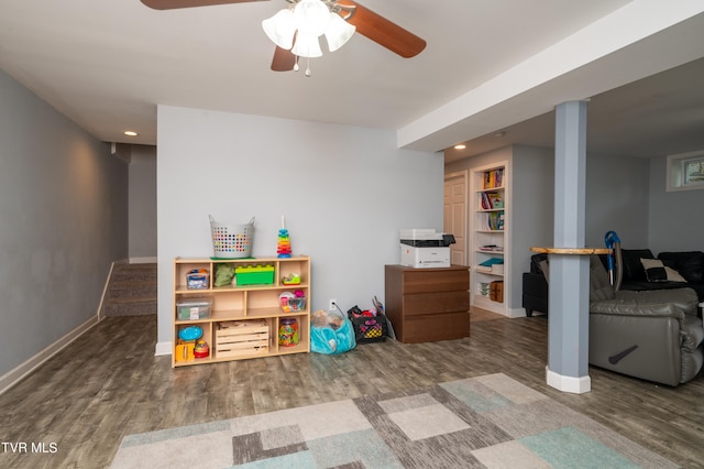 playroom with ceiling fan and dark wood-type flooring