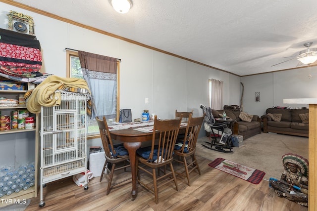 dining room featuring ceiling fan, wood-type flooring, a textured ceiling, and ornamental molding