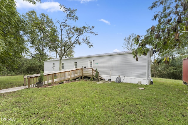 view of front facade with a deck and a front lawn