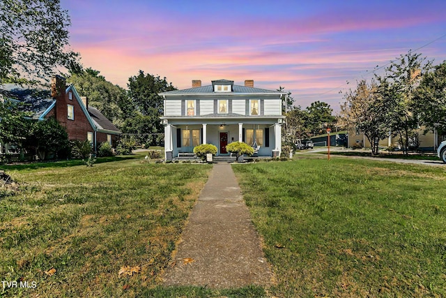 view of front facade with a lawn and a porch