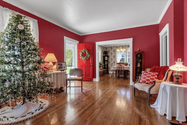 sitting room with a notable chandelier, ornamental molding, and hardwood / wood-style flooring