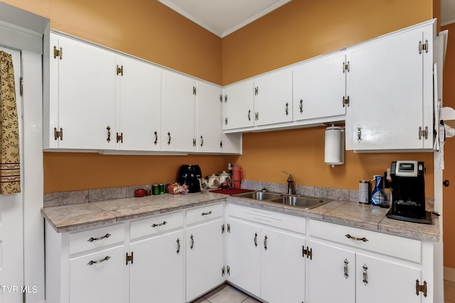 kitchen featuring ornamental molding, sink, and white cabinets