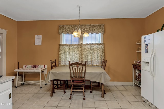 tiled dining space featuring ornamental molding and an inviting chandelier