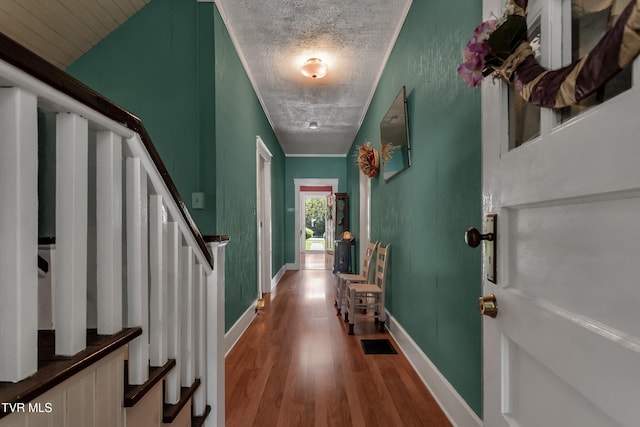 interior space with a textured ceiling and hardwood / wood-style floors