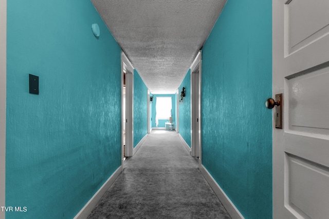 corridor featuring carpet and a textured ceiling