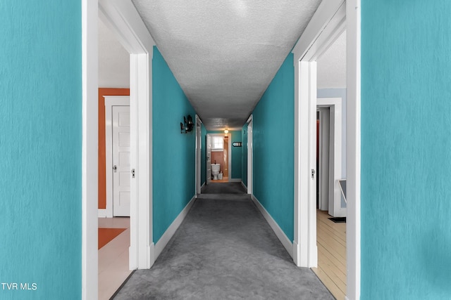 hall featuring a textured ceiling