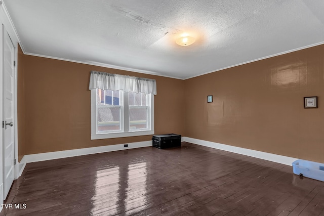 empty room featuring a textured ceiling, crown molding, and dark hardwood / wood-style floors