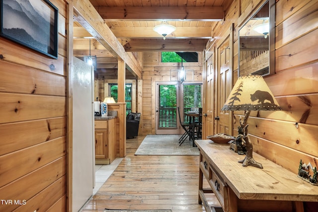 hall featuring beamed ceiling, wooden walls, wood ceiling, and light hardwood / wood-style flooring