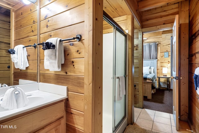 bathroom with vanity, wood walls, a shower with shower door, and tile patterned floors