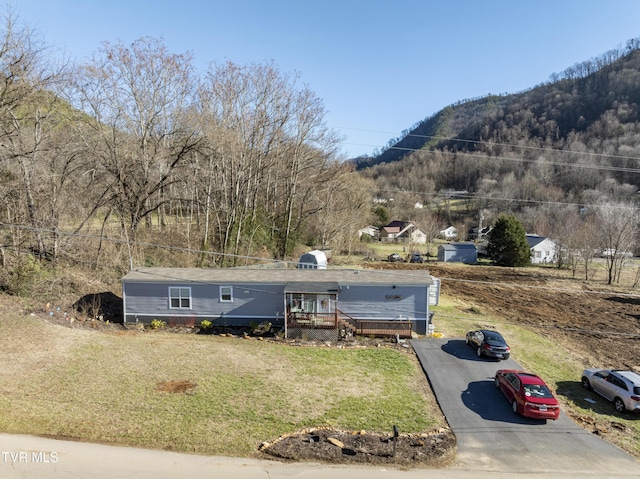 view of front of property with a front yard, driveway, and a mountain view