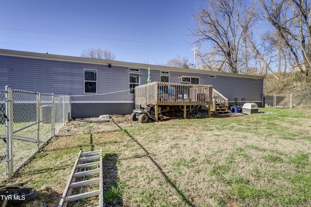 rear view of house featuring a gate, fence, a deck, and a yard