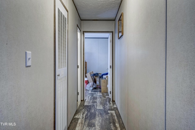 hallway featuring a textured ceiling and dark wood-style floors