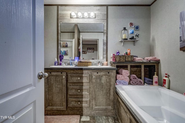 full bath featuring a garden tub, a sink, and double vanity