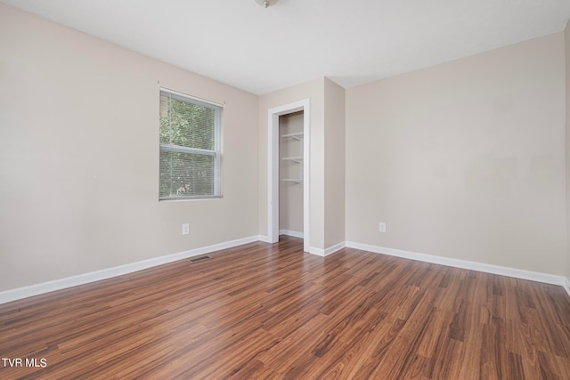 unfurnished bedroom with dark hardwood / wood-style floors and a closet