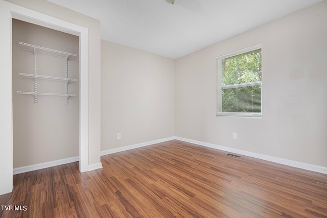 unfurnished bedroom with a closet and dark wood-type flooring