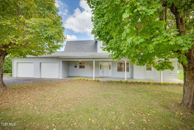 view of front of house featuring a front yard, a porch, and a garage