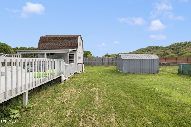 300 Wimberly Way, Bristol, TN 37620 - view of yard featuring a deck, a storage unit, a fenced backyard, and an outbuilding