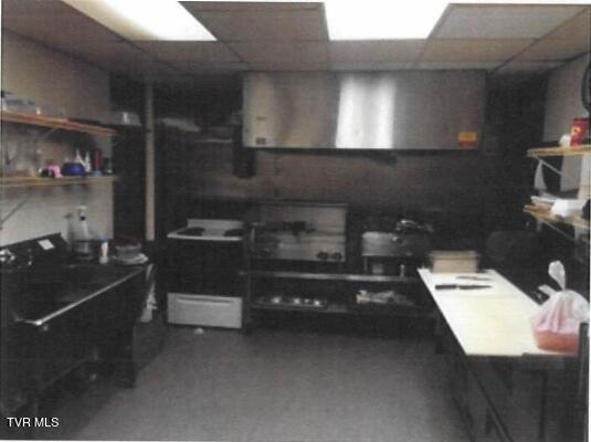 interior space featuring a paneled ceiling and wall chimney exhaust hood