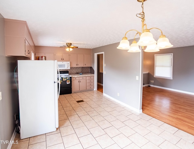 kitchen featuring hanging light fixtures, backsplash, white appliances, ceiling fan with notable chandelier, and light wood-type flooring