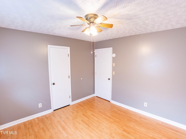 unfurnished bedroom featuring light wood-type flooring, ceiling fan, and a textured ceiling