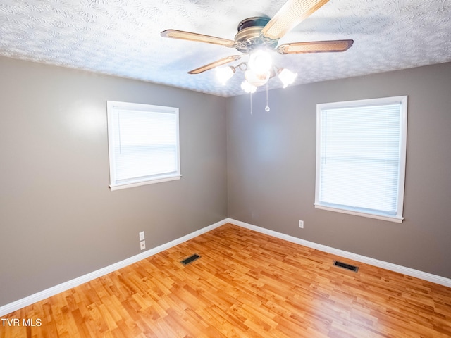 empty room with light hardwood / wood-style flooring and a textured ceiling