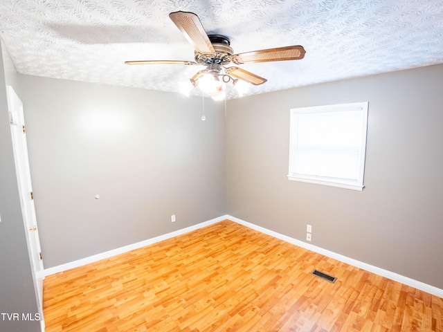 unfurnished room with wood-type flooring, a textured ceiling, and ceiling fan