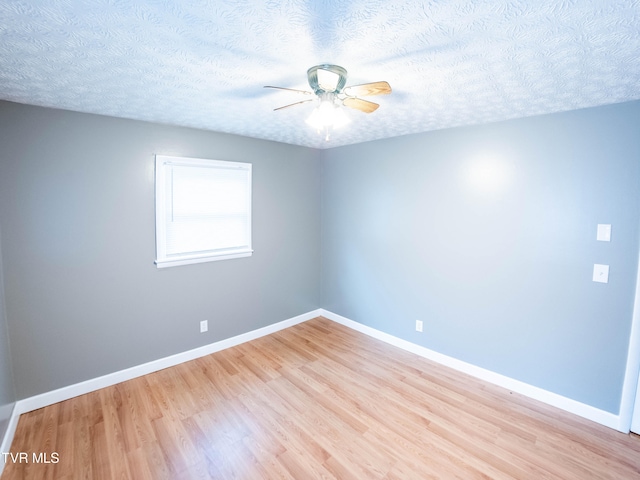 spare room featuring light hardwood / wood-style floors, ceiling fan, and a textured ceiling