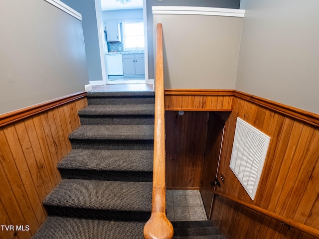 staircase featuring wood walls and sink