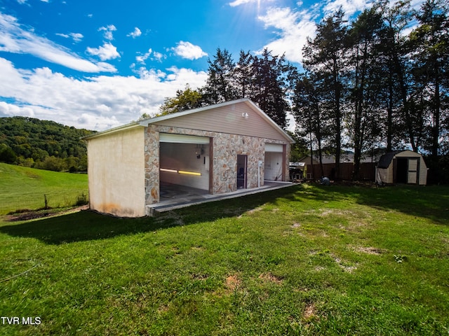 exterior space with a storage unit, a garage, and a yard