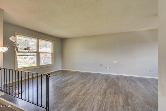 unfurnished room with a textured ceiling and hardwood / wood-style floors