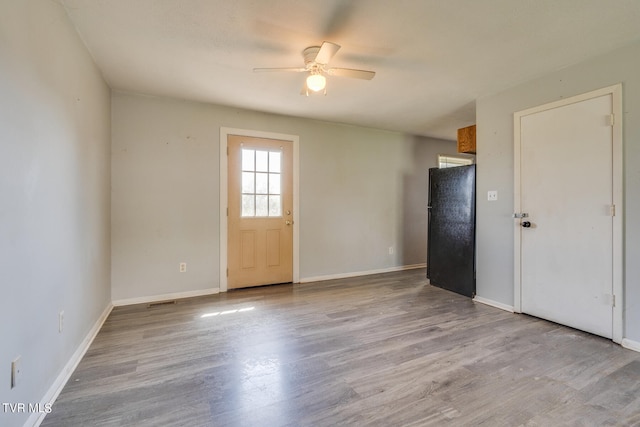 spare room with light wood-type flooring and ceiling fan