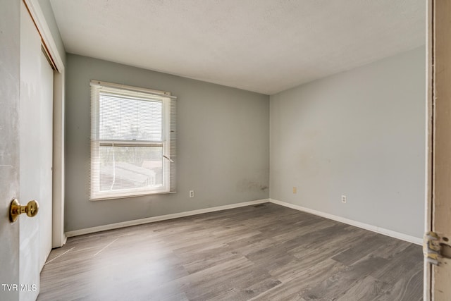 unfurnished room with a textured ceiling and hardwood / wood-style floors