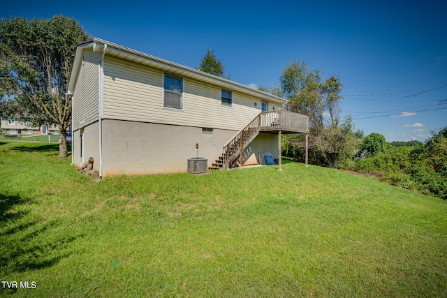 rear view of house featuring a wooden deck, a yard, and central AC