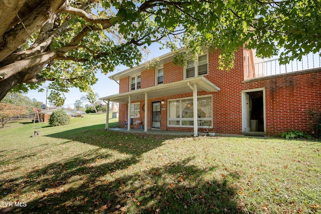 back of property with a lawn and a patio