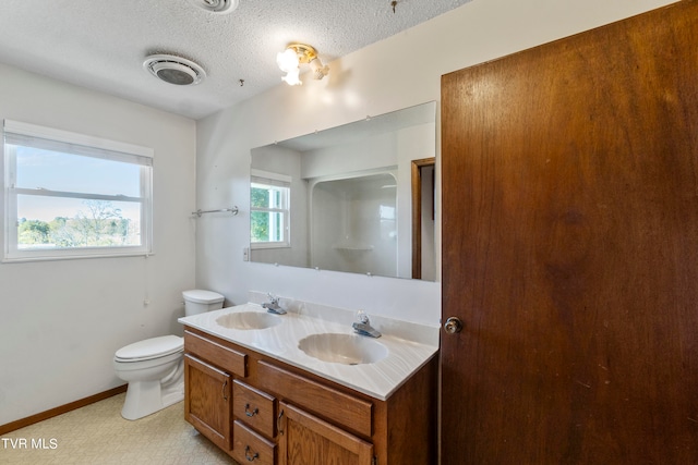 bathroom featuring vanity, toilet, and a textured ceiling