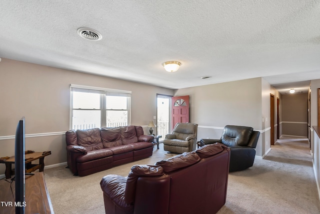 carpeted living room featuring a textured ceiling